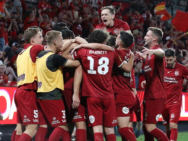 Craig Goodwin jumps over fellow players after a goal against Wellington at Coopers Stadium. Picture: Sarah Reed/Getty