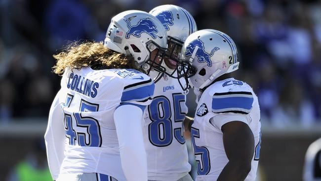 Jed Collins and Eric Ebron congratulate teammate Theo Riddick on a touchdown.