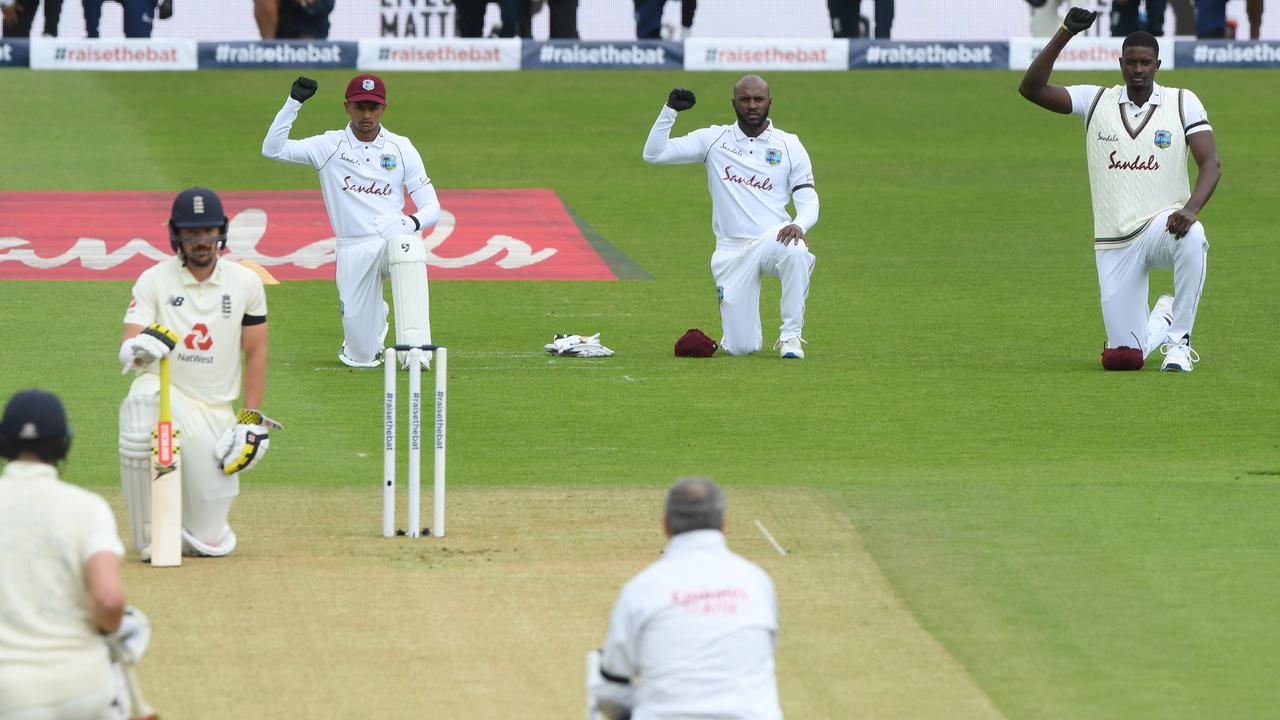 Players kneel before the start of play.