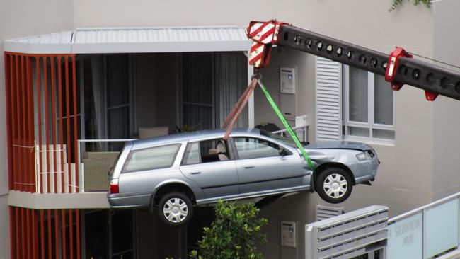 The Ford Falcon being lifted out of a courtyard in Seaview Ave, Newport after it took Jackson Smith, 8, on a solo ride in the runaway car.