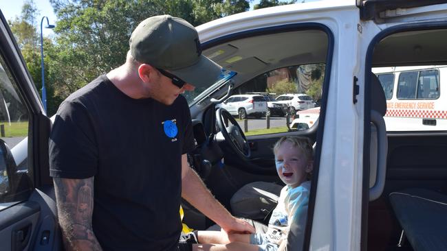 Scott and son Abel trying the siren in a police car