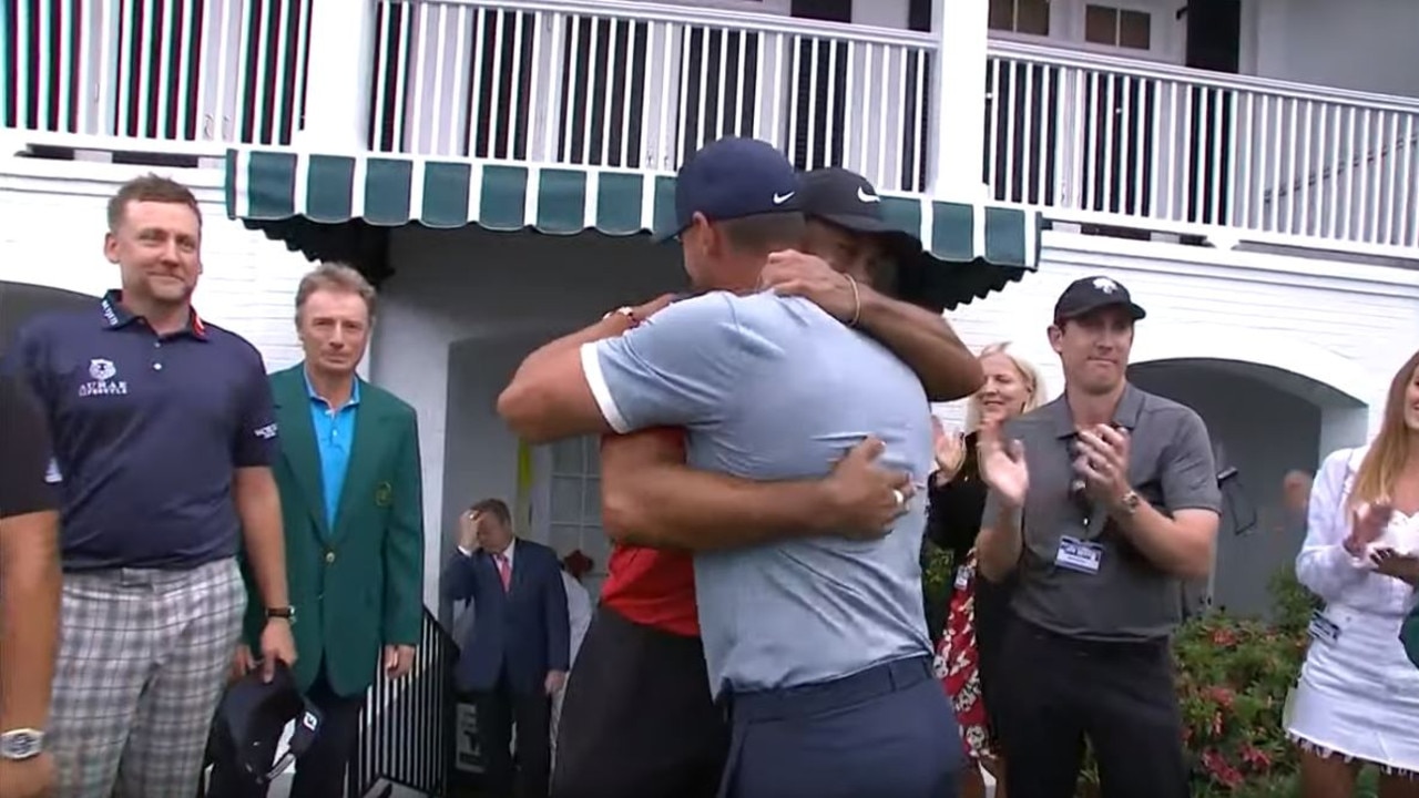Tiger Woods embraces golf stars after win.