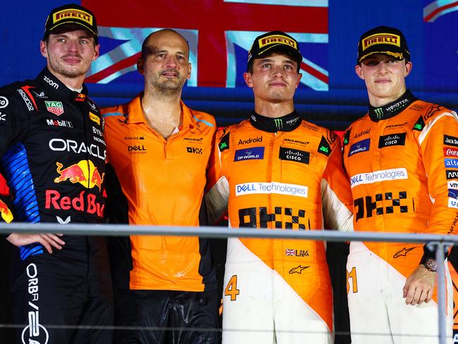 SINGAPORE, SINGAPORE - SEPTEMBER 22: Race winner Lando Norris of Great Britain and McLaren, Second placed Max Verstappen of the Netherlands and Oracle Red Bull Racing and Third placed Oscar Piastri of Australia and McLaren pose for a photo on the podium during the F1 Grand Prix of Singapore at Marina Bay Street Circuit on September 22, 2024 in Singapore, Singapore. (Photo by Joe Portlock/Getty Images)