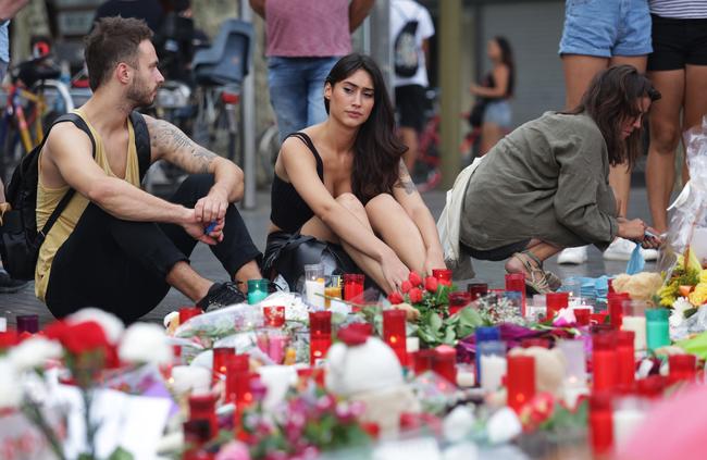 People sit in remembrance of the dead on Las Ramblas. Picture: Ella Pellegrini