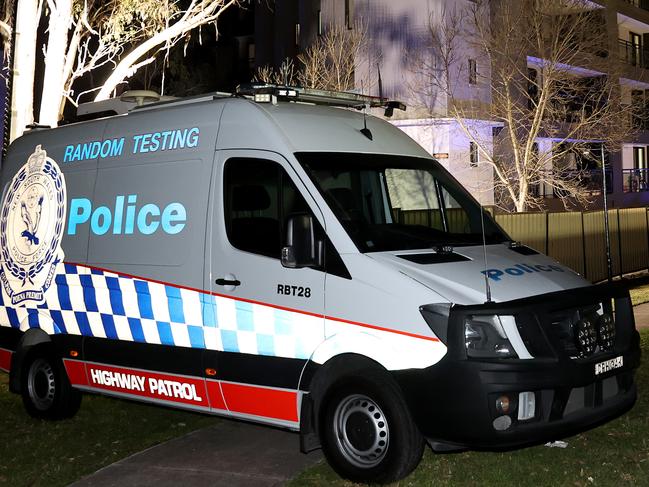 A 50 unit housing complex on Devitt St in Blacktown has gone into full lockdown under 24 hour police guard after 6 residents tested positive to Covid 19. Police set up a van at the rear of the building to keep watch. Picture: Toby Zerna