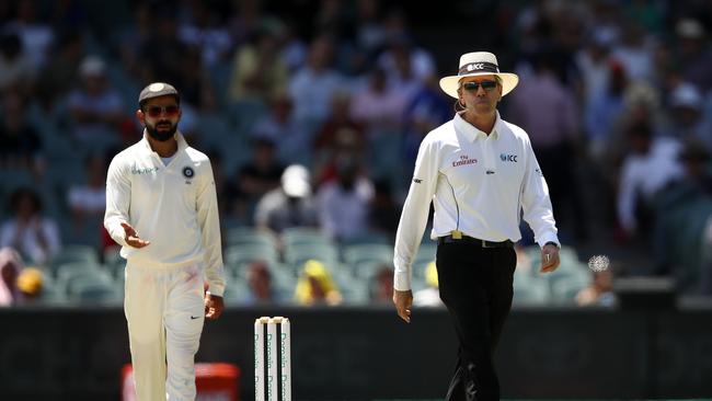 Virat Kohli of India speaks with Umpire Nigel Llong after a DRS decision was overturned during day five