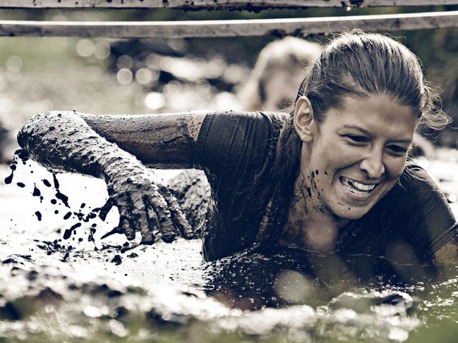 woman having fun crawling in mud, generic