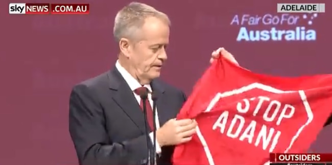 A protester hands Mr Shorten a “Stop Adani” banner on stage during the national party conference, in Adelaide. Sky News Australia. 