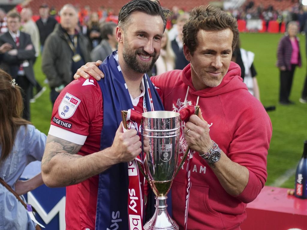 Wrexham co-owner Ryan Reynolds, right, and Wrexham's Ollie Palmer pose with trophy at the end of the English League One soccer match between Wrexham and Charlton Athletic at the Racecourse ground in Wrexham, Wales, Saturday, April 26, 2025. (AP Photo/Jon Super)