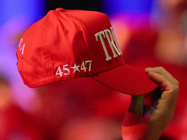 WEST PALM BEACH, FLORIDA - NOVEMBER 06: A supporter holds up a Trump hat during an election night watch party for Republican presidential nominee, former U.S. President Donald Trump at the Palm Beach Convention Center on November 05, 2024 in West Palm Beach, Florida. Americans cast their ballots today in the presidential race between Republican nominee former President Donald Trump and Vice President Kamala Harris, as well as multiple state elections that will determine the balance of power in Congress.   John Moore/Getty Images/AFP (Photo by JOHN MOORE / GETTY IMAGES NORTH AMERICA / Getty Images via AFP)