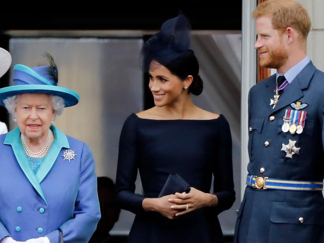 Britain's Queen Elizabeth II, Meghan, Duchess of Sussex and Prince Harry, Duke of Sussex stand on the balcony of Buckingham Palace in London. Picture: AFP