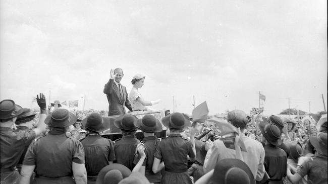 From their Land Rover, Queen Elizabeth II and Duke of Edinburgh Prince Phillip acknowledge the cheers of the children assembled at the schoolchildren's display at Mackay. Photo: The Courier-Mail Photo Archive