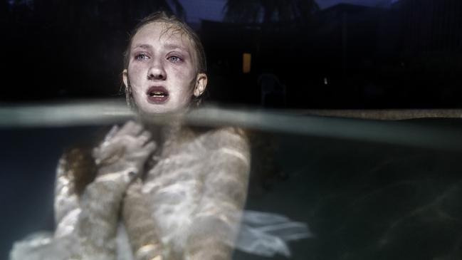 A woman immerses herself in a lake, by R J Poole