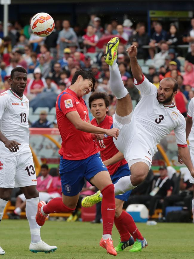 Oman's Jaber Al Owaisi kicks the ball away.