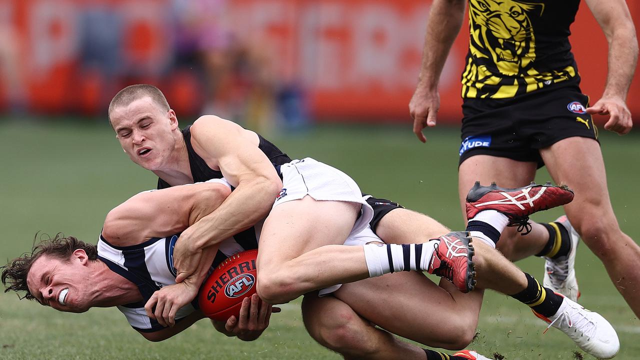 Max Holmes of the Cats gets a free kick after this tackle by Richmond’s Thomson Dow. Picture: Michael Klein