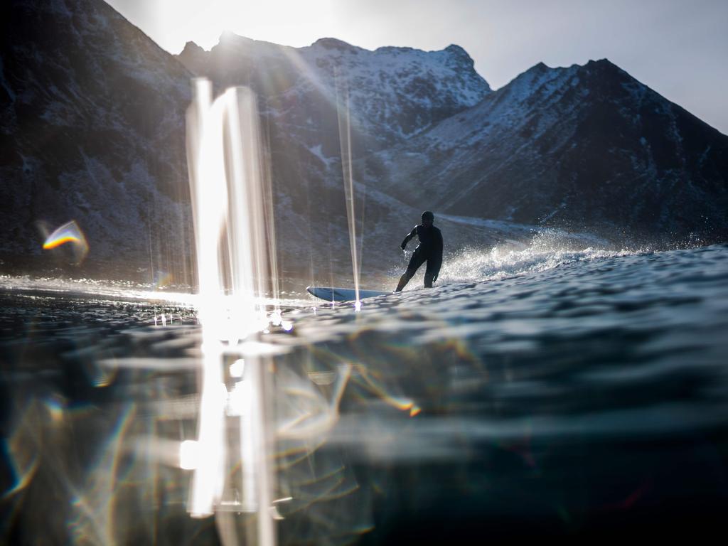 A surfer rides a wave on March 10, 2018 in Unstad, northern Norway, Lofoten islands, within the Arctic Circle as air temperature drops minus 13°C and water temperature above 4°C. Picture: AFP