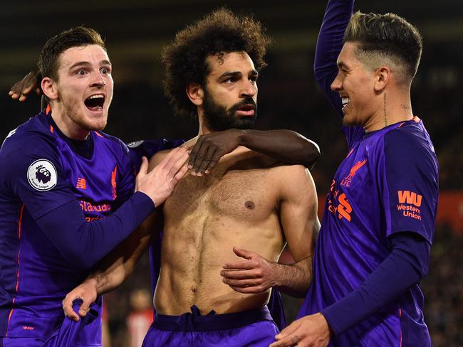 Liverpool's Egyptian midfielder Mohamed Salah (C) celebrates with Liverpool's Scottish defender Andrew Robertson (L) and Liverpool's Brazilian midfielder Roberto Firmino (R) after scoring their second goal during the English Premier League football match between Southampton and Liverpool at St Mary's Stadium in Southampton, southern England on April 5, 2019. - Liverpool won the game 3-1. (Photo by Glyn KIRK / AFP) / RESTRICTED TO EDITORIAL USE. No use with unauthorized audio, video, data, fixture lists, club/league logos or 'live' services. Online in-match use limited to 120 images. An additional 40 images may be used in extra time. No video emulation. Social media in-match use limited to 120 images. An additional 40 images may be used in extra time. No use in betting publications, games or single club/league/player publications. /