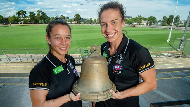 Collingwood AFLW players Ash Brazill and Brittany Bonnici at Victoria Park with the bell used at home games. Picture Jay Town