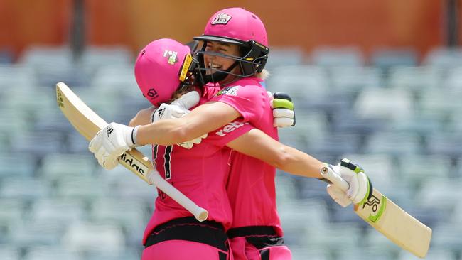 Alyssa Healy celebrates with Ellyse Perry after scoring a century during the WBBL match between the Sydney Sixers and the Melbourne Stars.