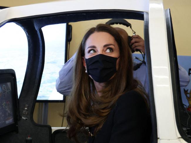 Britain's Catherine, Duchess of Cambridge, wearing black as a mark of respect following the death of Britain's Prince Philip, Duke of Edinburgh, and a face covering to combat the spread of Covid-19, sits in a flight simulator during their visit to 282 (East Ham) Squadron Air Training Corps in east London on April 21, 2021. - During the visit, the Squadron paid tribute to The Duke of Edinburgh, who served as Air Commodore-in-Chief of the Air Training Corps for 63 years. In 2015, The Duke passed the military patronage to The Duchess of Cambridge who became Honorary Air Commandant. (Photo by Ian Vogler / POOL / AFP)