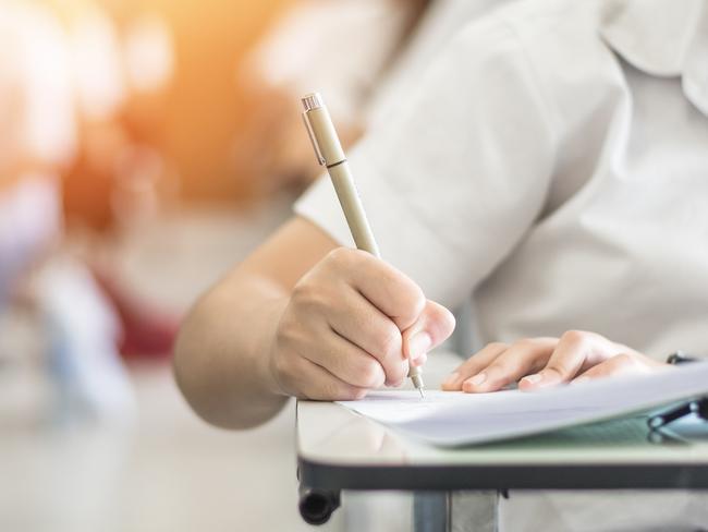 Exam with school student having a educational test, thinking hard, writing answer in classroom for university education admission and world literacy day concept