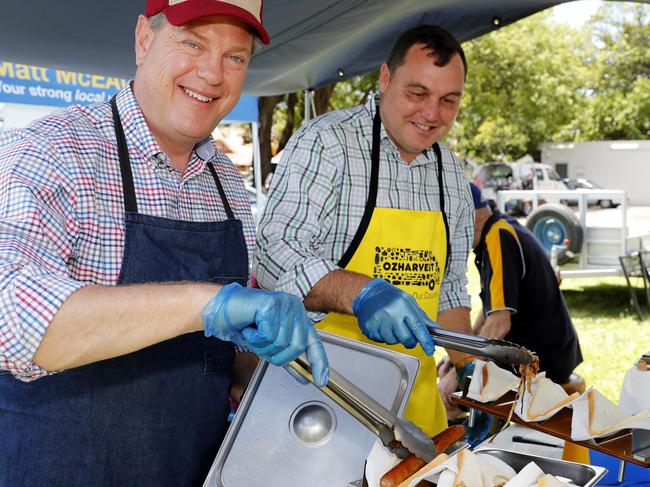 Queensland Opposition Leader Tim Nicholls talks to helps with making sausage sizzle during a visit to Redland Bay market, Brisbane, Sunday, November 12, 2017. Also shown is Matt McEachan (centre), candidate for Redlands. (AAP Image/Regi Varghese) NO ARCHIVING