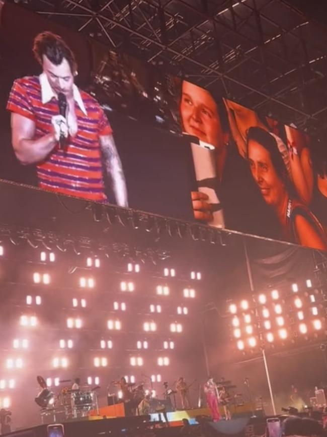 Styles read the sign out to the crowd during his Friday show.