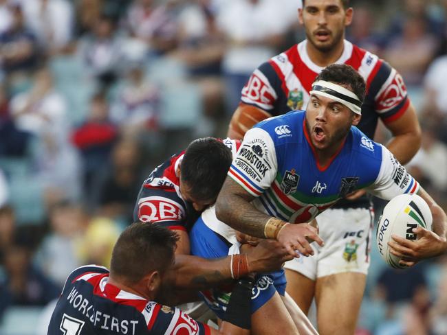 Jazz Tevaga is tackled by Roosters defence.