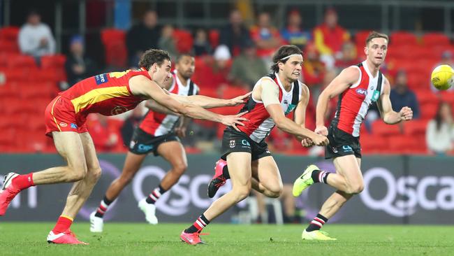 St Kilda’s Hunter Clark gets a handball away under pressure from Gold Coast’s Ben King. Picture: Chris Hyde/Getty Images