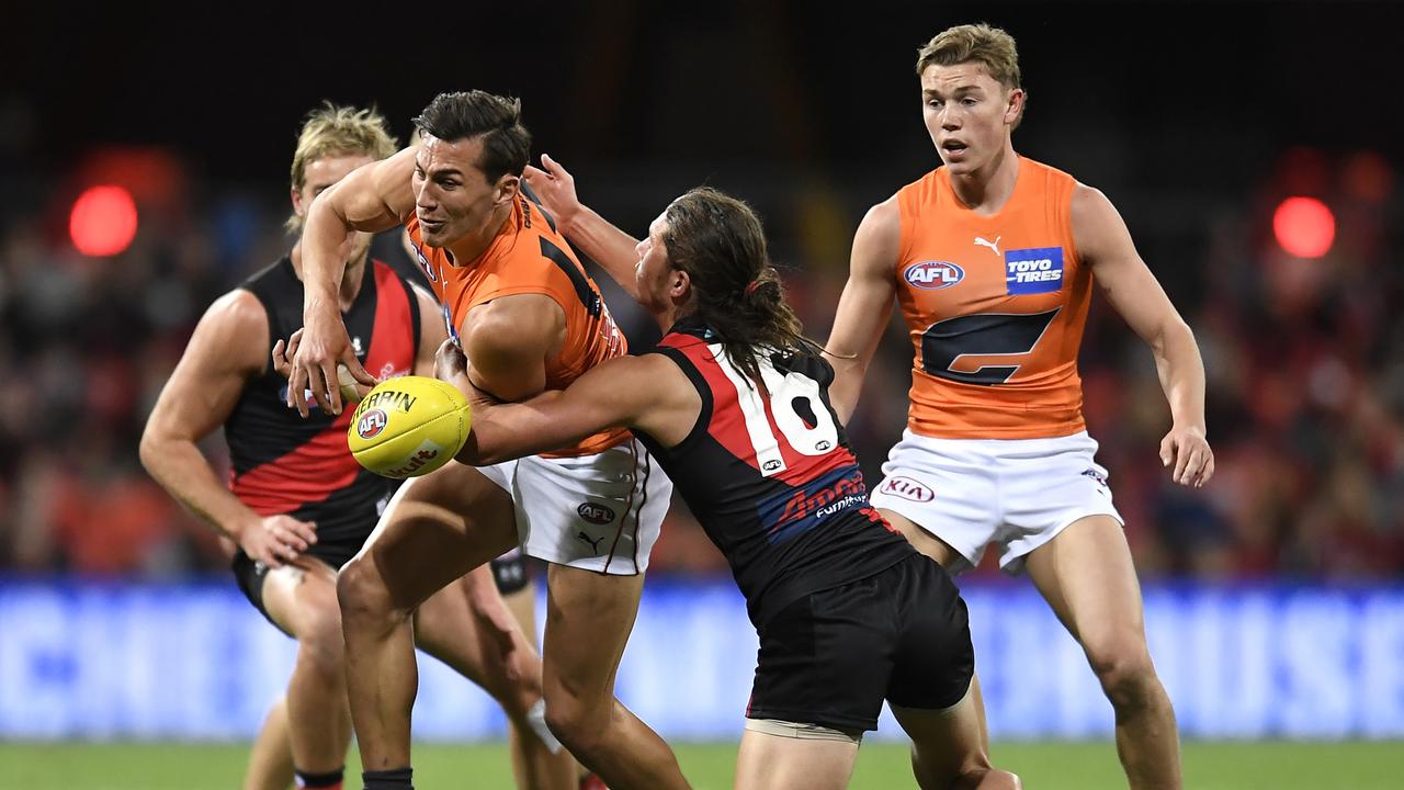 GOLD COAST, AUSTRALIA - JULY 25: Isaac Cumming of the Giants is tackled during the round 19 AFL match between Essendon Bombers and Greater Western Sydney Giants at Metricon Stadium on July 25, 2021 in Gold Coast, Australia. (Photo by Albert Perez/AFL Photos/via Getty Images)