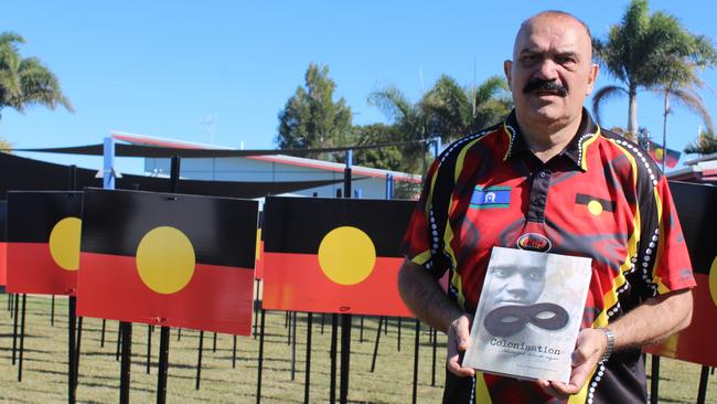 Dr Kerry Blackman with a book he co-authored Colonisation Through Black Eyes.