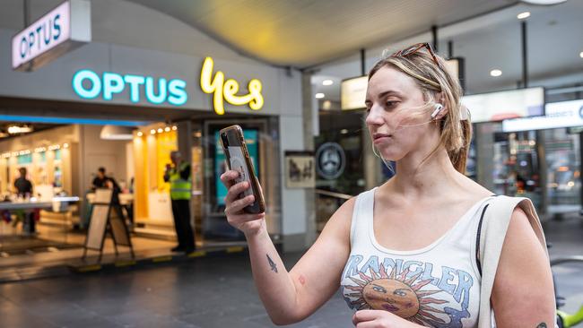 Optus customer Maddison Wallace checks her phone during Wednesday mass outage. Picture: Jake Nowakowski