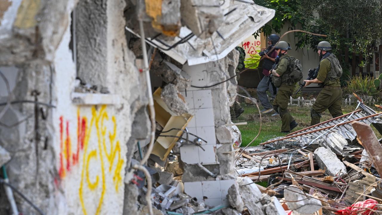 IDF Soldiers walk near a building destroyed by Hamas militants. Picture: Alexi J. Rosenfeld/Getty Images