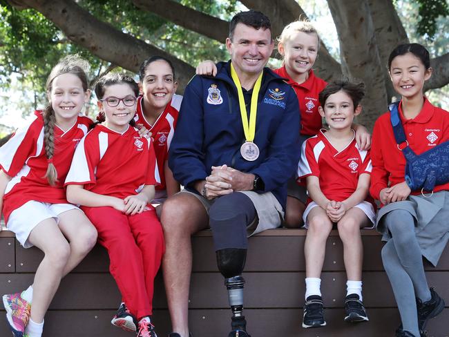 Invictus Games Athlete and Former Army Commando, Garry Robinson is pictured at Canterbury South Public School with (left) Elizabeth Turner, 8, Georgia Scrivener, 9, Melia Antonopolous ,10, Alice Bursill Dickinson, 9, Elliot Foxlee, 8, and Beatrice Shimada, 9, who have written letters to encourage the athletes. Picture: David Swift.