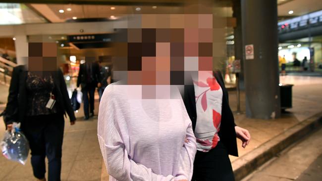 A member for the Colt family is escorted by police through Sydney Domestic Airport last April. Picture: AAP Image/Joel Carrett