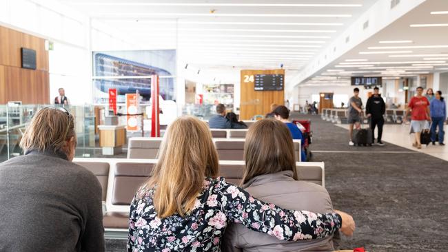 Holly van Vliet and her parents wait for a delayed flight to Alice Springs at Adelaide Airport on Christmas Day. Picture: The Advertiser / Morgan Sette