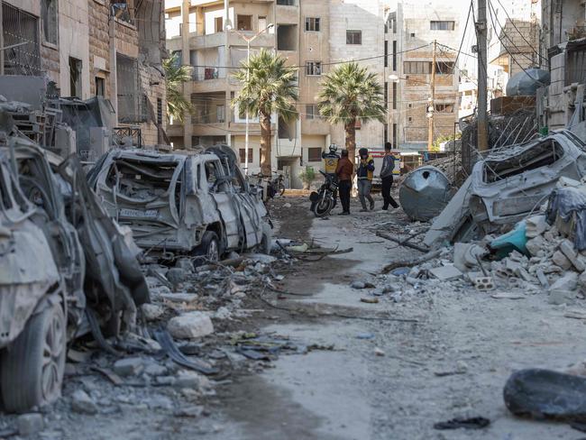 Locals and White Helmets rescuers among building rubble at the site of a reported air strike in Idlib. Picture: AFP