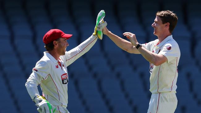 Brendan Doggett celebrates with Harry Nielsen after they combined to take the wicket of Mitchell Owen for one. (Photo by Sarah Reed/Getty Images)