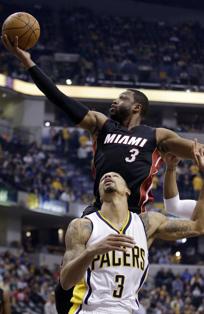 Miami Heat's Dwyane Wade, top, puts up a shot against Indiana Pacers' George Hill during the first half.