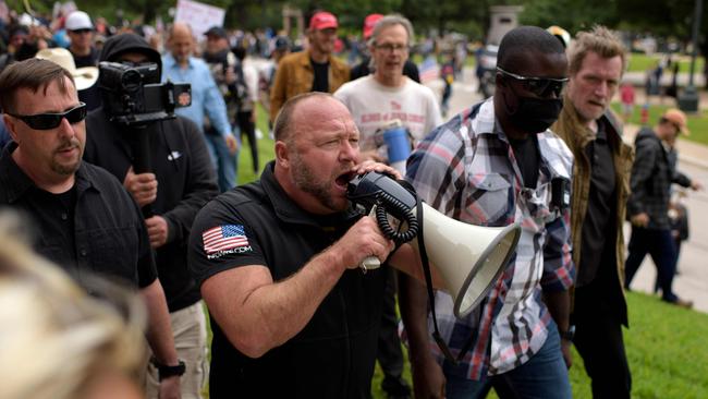 Far-right commentator Alex Jones yells into a microphone during the "Reopen America" rally on April 18, 2020, at the State Capitol in Austin, Texas.