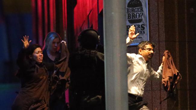 Hostages run towards armed tactical response police as they run to freedom. Picture: AP Photo