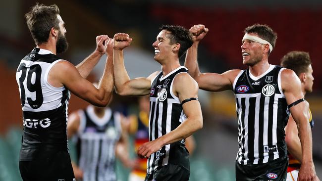 Port Adelaide’s Justin Westhoff, left, Connor Rozee and Brad Ebert celebrate against the Crows at Adelaide Oval on Saturday. Picture: Getty Images