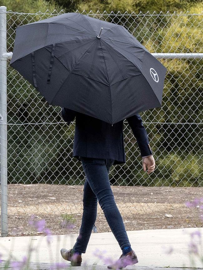 Hosein Tavakoli shielded from view under an umbrella outside court. Picture: NCA NewsWire/Emma Brasier