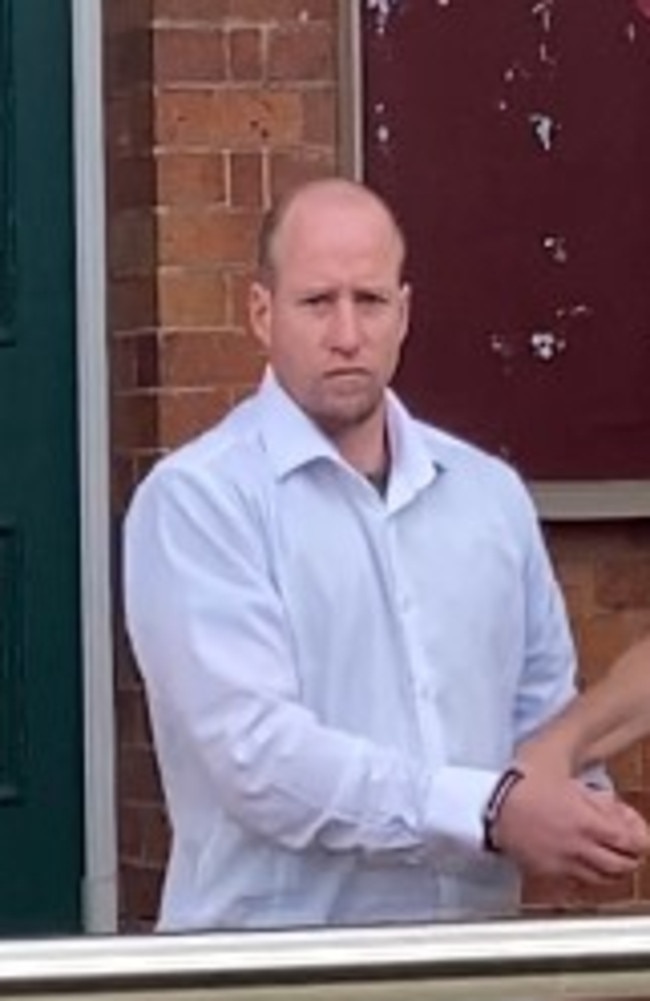 Andrew James Cougan, 37, of Gympie, is escorted from District Court after pleading guilty to charges including grievous bodily harm after hitting a woman so hard she suffered a brain injury that required surgery.