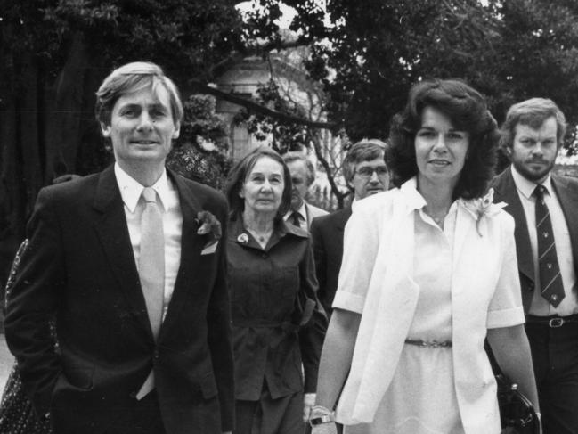 SA politician John Bannon and his wife Angela walking through the garden at Government House, Adelaide, for his swearing-in as SA Premier.  His mother, Mrs Joyce Bannon, is behind him to the right and advisers Geoff Anderson and Mike Rann are behind Angela to the right, 10 Nov 1982.  (Pic by unidentified staff photographer)