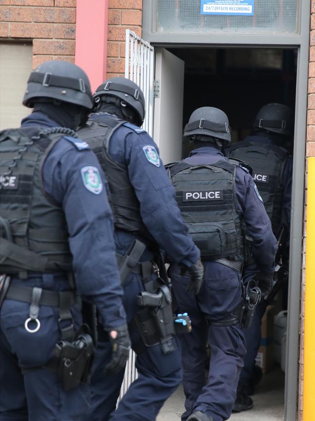 Heavily-armed drug squad police raid a property. Picture: John Grainger