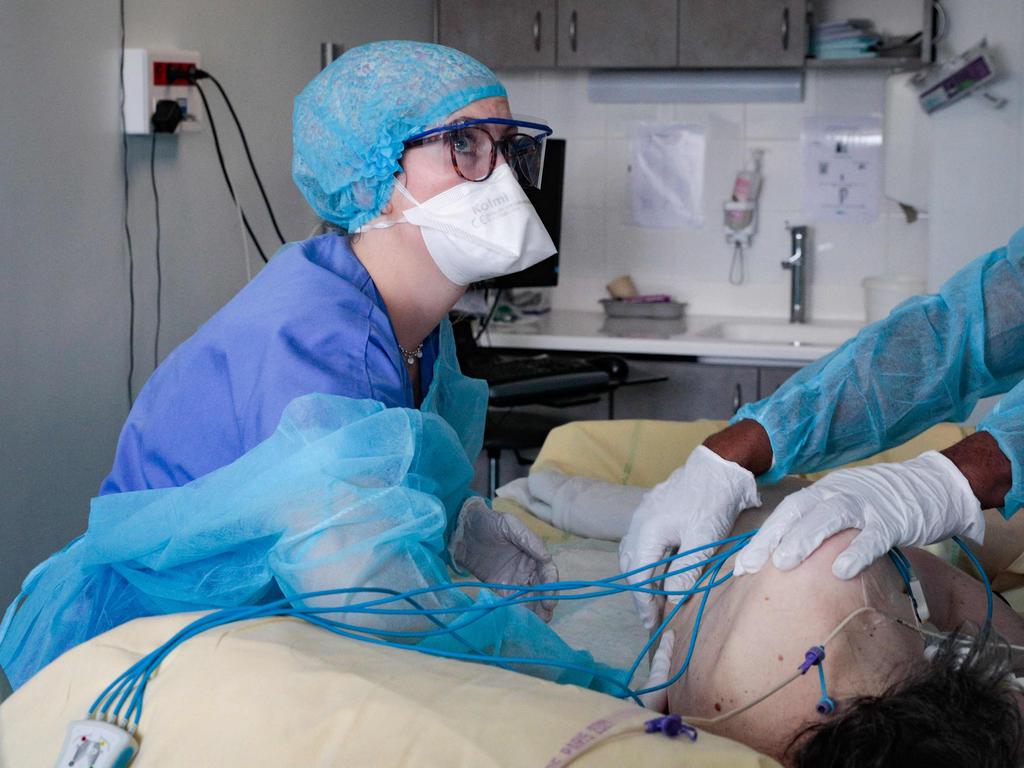 Nursing assistants tend to a patient infected with the coronavirus at the reanimation unit of the Antoine Beclere hospital in Clamart, outside Paris, on December 23. Picture: AFP