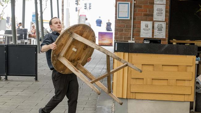 Staff at Charlie's Cafe &amp; Bar in Surfers Paradise putting furniture away. Picture: Jerad Williams