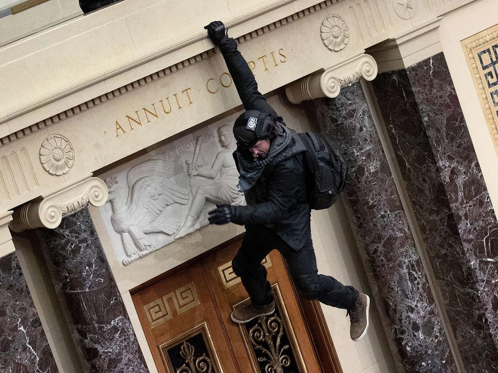 A Trump supporter jumps from the public gallery to the floor of the Senate chamber. Picture: Win McNamee/Getty Images/AFP