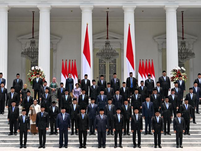 Indonesia's President Prabowo Subianto (front centre L) and Vice President Gibran Rakabuming Raka (front centre R) pose with newly sworn-in cabinet ministers in front of the Presidential Palace in Jakarta on October 21, 2024. (Photo by BAY ISMOYO / AFP)